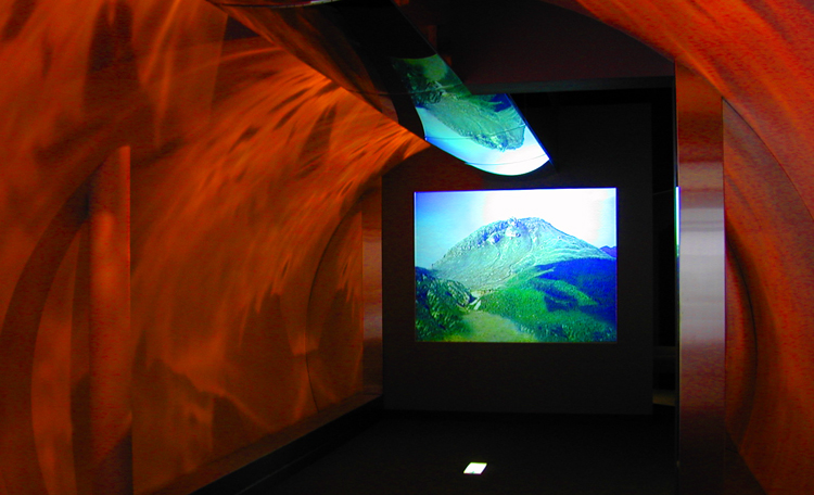 『マグマゲート』<br>記念館に来館者が入るとセンサーが感知。4台のプロジェクターによるマグマがトンネル壁面を赤く染め上げ、平成大噴火による普賢岳の変貌が映し出されます。